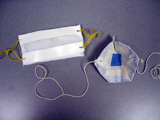 Photo shows two filters, one made of cloth and cotton batting with rubber bands to secure the mask over ears, the other from coffee filters and cloth with two side strings to tying.