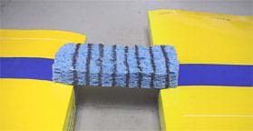 Photo shows a sponge with eight parallel black lines drawn around it spanning two stacks of books ~3 cm above a table surface.