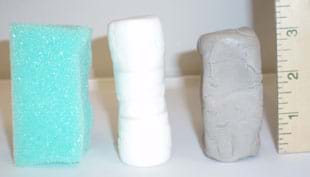 Photo shows columns of foam, marshmallows and clay lined up by a ruler, so you can see their 3-inch heights.