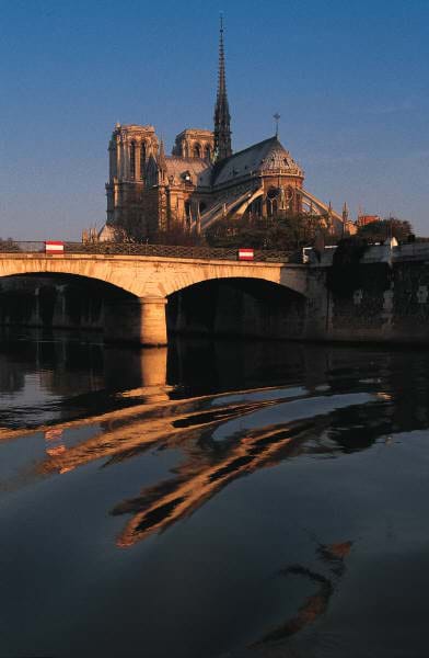 A graceful multi-arched bridge provides access to an island with a cathedral.