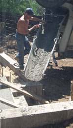 Photo shows concrete pouring down a trough.