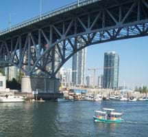 Photo shows a highway bridge with an arching steel truss support system under its deck.