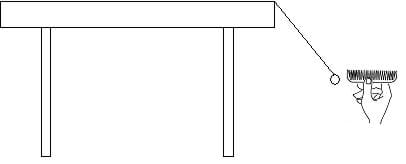 A drawing of the side view of a table with a piece of string hanging from the edge of the table top at a 45-degree angle to the right. At the end of the string is an O-shaped piece of cereal. To the right of the piece of cereal, a hand holds a comb near the cereal, but not touching it.