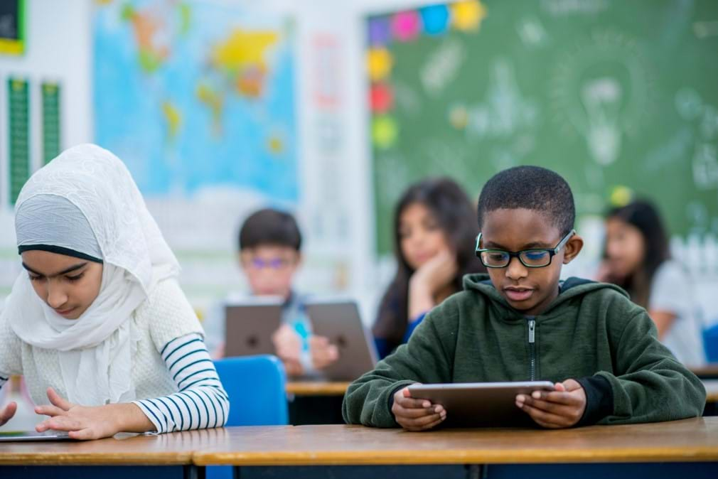 An image of students in a classroom using tablets. 