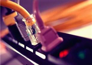 A photograph shows a surge protector with four electrical cords plugged into it.