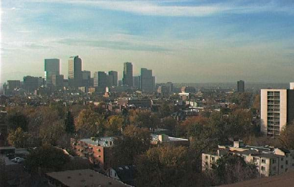 A landscape photo shows a hazy brown cloud hanging around a collection of skyscrapers.