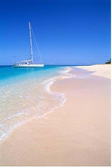 A photograph of sailboat anchored at a beach.