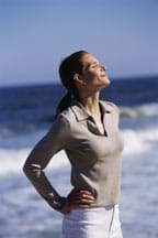 Photo shows a woman with eyes closed, facing the warm sun's rays.