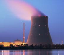 Photo shows glow of lights and emissions of a tall and wide nuclear power plant tower.