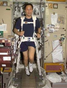 A photograph showing an astronaut running on a treadmill in outer space.