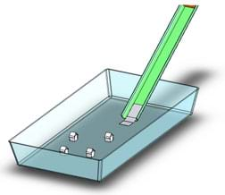 Diagram shows a chute, containing some sand at the top, angled into a tub, with a small house at the bottom of the chute.