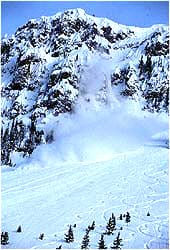 Photo shows a blur of snow moving down a steep, rocky slope.