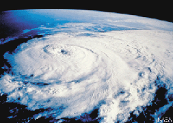 The hurricane appears as a large swirling white disk of clouds with a small clear patch at the center.