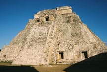 Photo shows a weathered, pyramid-shaped stone structure.