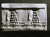 Photo of a stone with images of people, animals and stacked pyramids. 