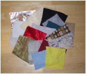 Photo shows pieces of felt, aluminum foil, bubble plastic wrap, cotton, fleece, lace, brown paper and other fabric