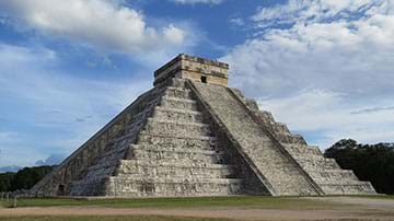 Image of stepped pyramid in cloudy skies.