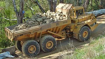 Photograph of dump truck carrying rocks. 