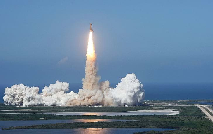 Photo shows a rocket blasting off with the exhaust from the burning fuel spreading rapidly.