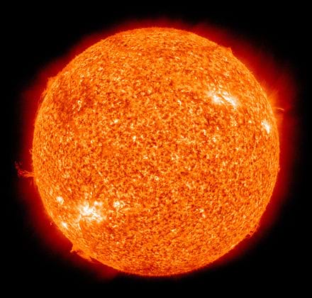 Photo shows the sun with solar flares erupting from the surface.
