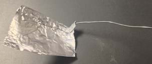 A piece of aluminum foil covers a wire.