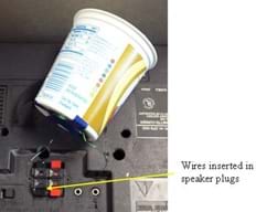 A photograph shows a yogurt cup speaker attached to the radio speaker plugs. Arrows point to where the two speaker wires are inserted in the speaker plugs.