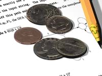 Photo shows a few coins (quarters, dimes, nickle, penny).