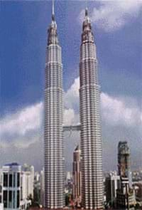 A photograph shows two twin skyscrapers with a horizontal bridge connecting them midway.