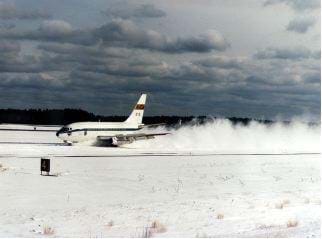 A photograph shows an airplane landing on a snowy runway.