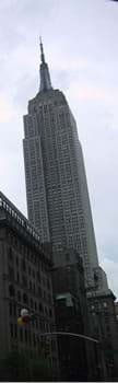 A tall gray skyscraper with a pointed antenna at its peak.