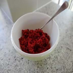 A photograph shows a foam cup containing a handful of grated beet, which looks like dark red food shreds.