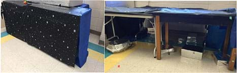 Two photographs: Two tables covered with blue and black plastic tablecloths all the way to the floor. With the cloth lifted, a scattering of silver boxes and foil pans are seen on the floor under the table, creating a hidden maze.