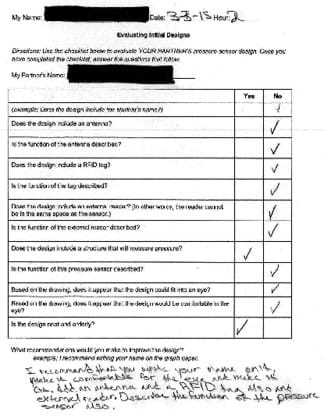 A scan of a paper form containing an 11-row table with "yes" and "no" columns. The 11 rows contain questions, such as "Does the design include an RFID tag?" Hand-drawn check marks fill the "yes" and "no" columns, mostly in the "no" column. A hand-written recommendation at the bottom reads: "I recommend that you write your name on it, make it comfortable for the eye and add an antenna and an RFID tag, also an external reader. Describe the function of the pressure sensor also."