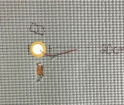 A photograph shows the rubber mat of Figure 1 with a large notch located near sensor B. The notch is so deep that the tabletop can be seen through the hole in the mat.