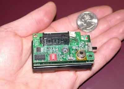 A photograph shows an open hand holding what looks like a small circuit board and a quarter (for scale). The sensor is more than four times the size of the quarter.