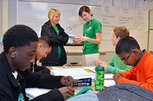 A photograph shows four teens at a table in a classroom working intently (cookie mining).