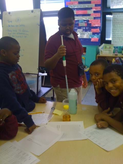 Photo shows four students using a serological pipette looking at the flow of shampoo and honey.