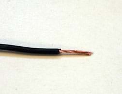 A photograph shows a piece of insulated wire with about an inch of exposed copper wire visible at the end of the wire where the black insulating material is removed.