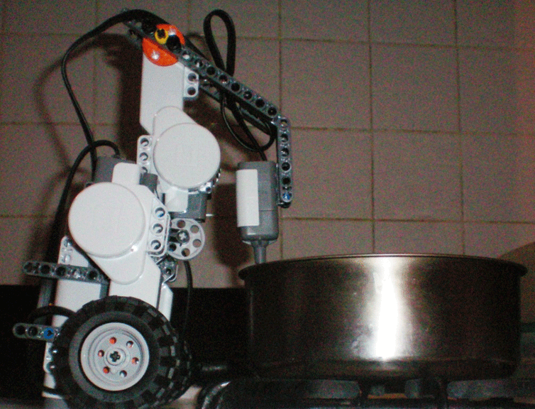 Photo shows the robot along with the temperature sensor recording the data on top of a stove.