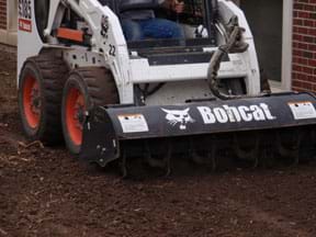 Poto shows a skid steer (or 4-wheeled bobcat)  tilling dirt.
