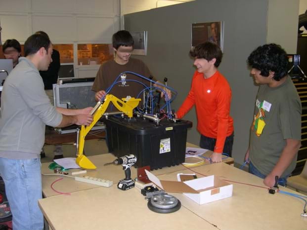 Photo shows four students at a table using PFPDs. 