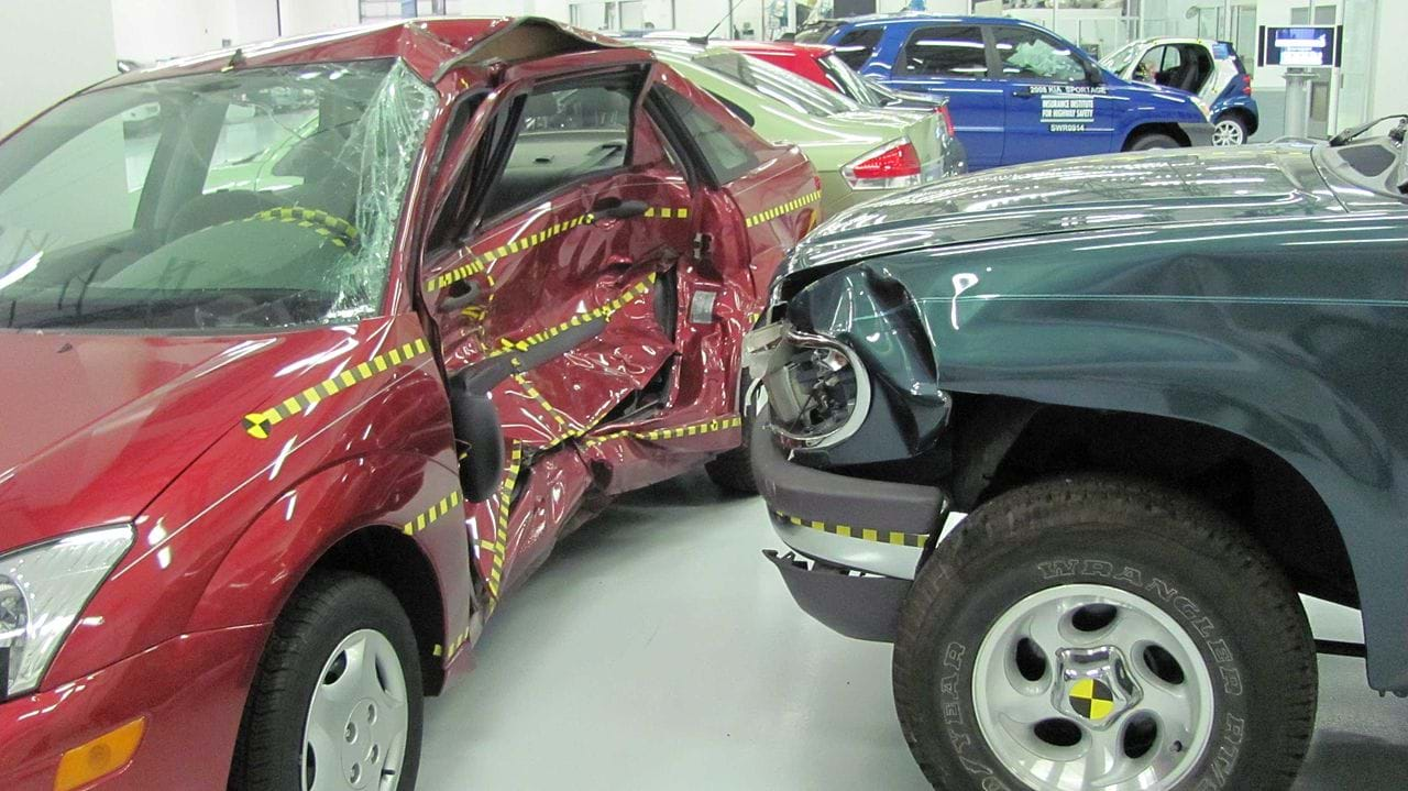 A photo shows one car crashed into the side of another car, both with damage.