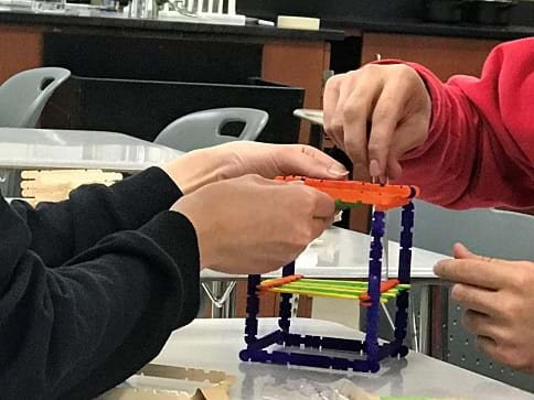 Students construct a sample holder with popsicle sticks to hold the food dye sample.