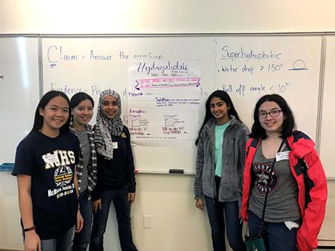 A student team standing in front of their hydrophobic poster.