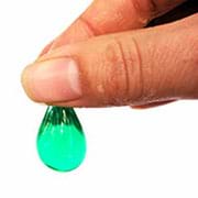 A photograph shows a thumb and index finger pinching the top of a green algal model—which looks like a transparent thumbnail-sized sack of green water—to demonstrate the existence of a polymer wall around the liquid.