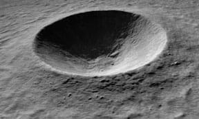 A black and white photograph shows a round concave indentation in a slightly textured surface.