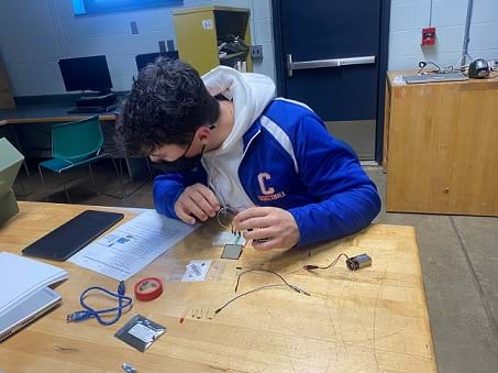 A student is following instructions to build a breadboard circuit with Arduino, an FSR, and an HC-05 Bluetooth module.