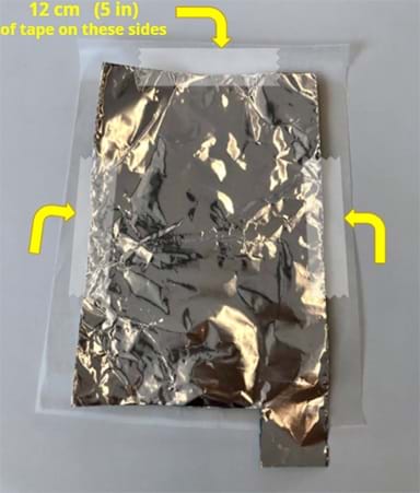 A photograph shows a piece of tin foil in the shape of a backwards “P” and 12 cm of tape placed on each side except for the side with the tail.