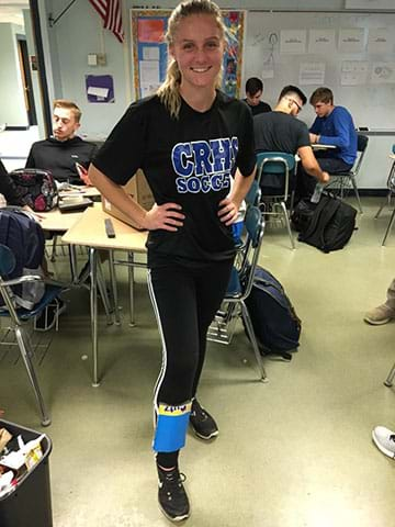 A female student models her cardboard shin guard.