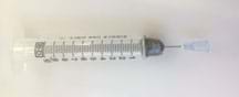 Photo shows a clear, plastic 20 ml syringe, whose opening is covered in duct tape. A pin is stuck inside the duct tape-covered orifice to make a tiny hole.